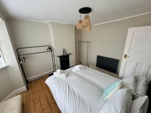 ein Schlafzimmer mit einem weißen Bett und einer Couch in der Unterkunft Comfortable 2-Bed Home near Swansea Bay in Morriston + 11 Fotos