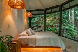 a bedroom with a bed in a room with windows at The Nest in San Luis
