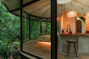 a glass room with a table and a chair at The Nest in San Luis +29 photos