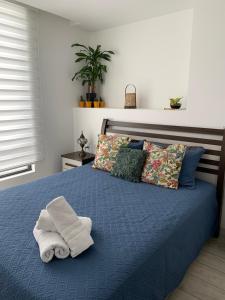 a bedroom with a bed with towels on it at Espectacular departamento con vista a la Carolina con Generador de luz in Quito