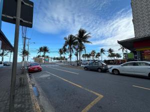a street with cars parked on the side of the road at Pé na areia em Nova Mirim com Wi-Fi e conforto! in Samaritá
