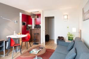 a living room with a blue couch and a table at FirstName Toulouse Résidence in Toulouse