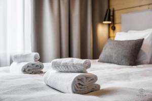 Dos toallas apiladas en una cama en una habitación de hotel. en Levin Lyhty Bella by Hilla Villas, en Kittilä