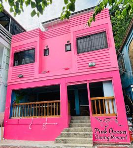 a pink office building with a pink exterior at Pink Ocean Diving Resort Sabang Puerto Galera in Puerto Galera