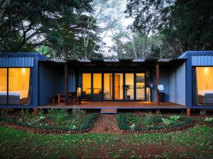 a blue tiny house with a porch and windows at Umdoni Farm Lodge in Mahlanya