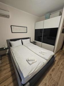 a bedroom with a large bed with white sheets at Charming Apartment Borovets Gardens D16 in Samokov
