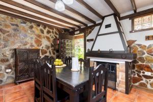 Un comedor con mesa y chimenea. en Home2Book Icod Rural Escape Pool BBQ, en El Amparo
