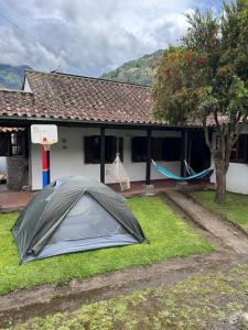 a tent in the grass in front of a house at casa Montisora in Baños