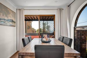 a dining room with a wooden table and chairs at Sienna Arches - Modern Family Haven near Ocean Baths in The Entrance