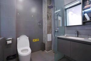 Un baño con inodoro, lavabo y ducha. en Lingli Home Hotel, en Dali