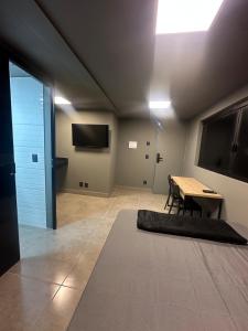 ein Wohnzimmer mit Tisch und Fernseher in der Unterkunft Kit Aconchegante na Asa Norte - Centro in Brasilia