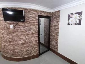 a room with a brick wall with a flat screen tv at Nice Luxury Homes in Nelspruit