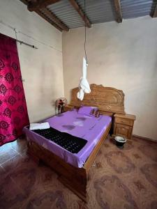 にあるChez Fatou - Immersion au cœur du Sénégalの紫色のベッドが備わる部屋