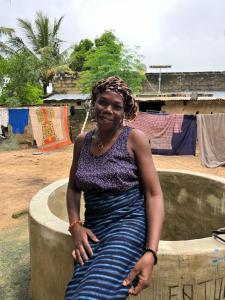 にあるChez Fatou - Immersion au cœur du Sénégalの噴水の上に座っている女性