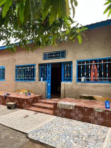 にあるChez Fatou - Immersion au cœur du Sénégalの青いドアと階段が正面にある建物