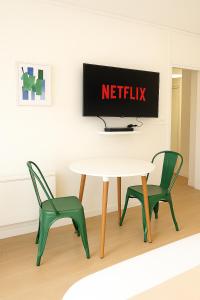 Una habitación con una mesa y dos sillas y un cartel de Netflix. en Appartement de charme Digoin #8, en Digoin