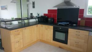 une cuisine avec des armoires en bois et un comptoir noir dans l'établissement Maison familiale idéale pour vacances, à Saint-Georges-dʼOléron 3 autres photos