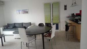 un salon avec une table et des chaises blanches dans l'établissement Maison familiale idéale pour vacances, à Saint-Georges-dʼOléron