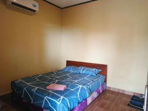 a bedroom with a bed with a pink bag on it at Pondok Wisata Karapyak Jajapin in Nusa Were