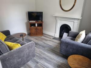 a living room with two couches and a fireplace at Adare House Newbridge in Newbridge