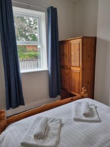 a bedroom with a bed with two towels on it at Adare House Newbridge in Newbridge