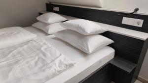 uma cama branca com quatro almofadas em Darázshegyi Panzió gluténmentes félpanzióval is em Mátraszentimre mais 11 fotografias