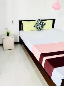 a bedroom with a large bed with colorful pillows at Geethani Tourist Home Polonnaruwa in Polonnaruwa
