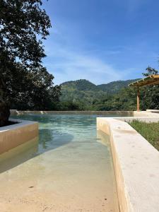 a pool of water with mountains in the background at Oasis Hotel & Resort Mazamitla in Caliguana +46 photos