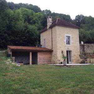 ein großes Steinhaus auf einem Feld mit Hof in der Unterkunft Les Tanneries in Flavigny-sur-Ozerain