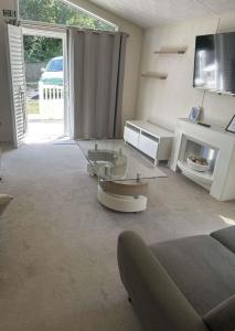 a living room with a couch and a glass table at Woodland Lodge - 2 Bedroom Spacious Lodge Sleeps 4 in Hastings