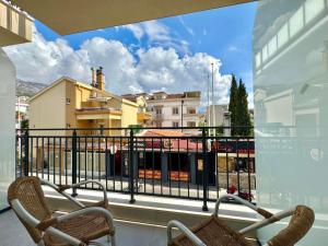 a balcony with two chairs and a view of a city at Hotel Lobo Budva in Budva
