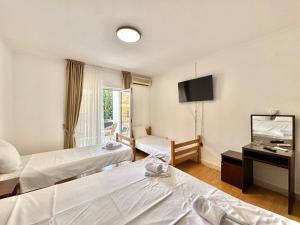 a hotel room with two beds and a flat screen tv at Hotel Lobo Budva in Budva +61 photos