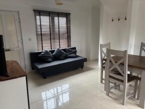 a living room with a couch and a table and a chair at 2 Willow Cottage in Takeley