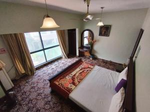 カラチにあるHillTop Hotelのベッドと大きな窓のある寝室