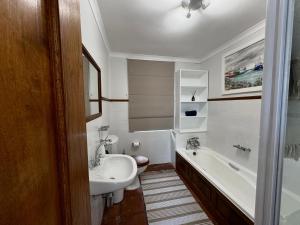 a bathroom with a sink and a toilet and a tub at San Ma Lou in Paternoster