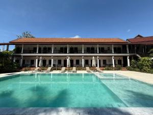 a large swimming pool in front of a house at Vangsavath Hotel in Luang Prabang