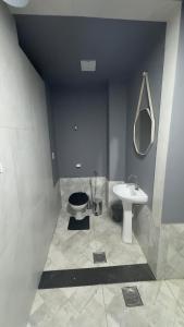 a bathroom with a sink and a toilet and a mirror at Rooftop Studio Premium in Bom Despacho