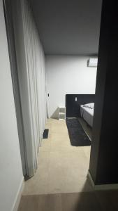 a bedroom with a bed and white curtains in it at Rooftop Studio Premium in Bom Despacho