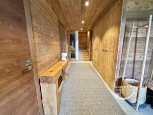 a hallway with a wooden wall with a wooden bench at Chalet neuf La Marmotière - Vue sur la Montagne in Combloux +56 photos