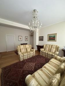 a living room with couches and a chandelier at Residenza Maria Luisa in Padova