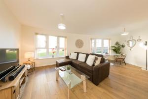 ein Wohnzimmer mit Sofa und Tisch in der Unterkunft Monart Stylish City Centre Apartment, 2 Bed, sleeps 6 in Perth