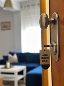 una puerta con un cartel en la sala de estar en Apartman Radmanović, en Banja Luka
