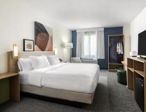 バーズタウンにあるSpark by Hilton Bardstownの大きなベッドとテレビがあるホテルの部屋