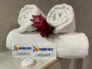 two towels and two packages of mensumes fuel on a table at Karaibes Hotel in Le Gosier