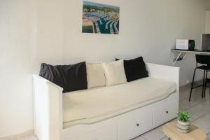 a white couch sitting in a living room at 400m de la mer, grand studio lumineux en centre-ville in La Grande-Motte