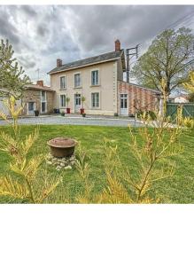 OironにあるChambre d'Hôtes d'Athénaïsの芝生に鳥の水浴び場がある庭のある大きな家