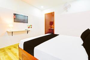 a bedroom with a bed and a tv on the wall at Hotel O Stayo Inn in Hyderabad +21 photos