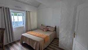 a small bedroom with a bed and a window at Kaz Kreol in Trou d'Eau Douce