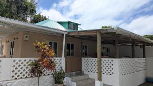 a house with a white fence and a pergola at Kaz Kreol in Trou d'Eau Douce