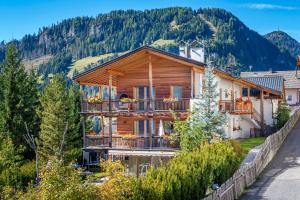 Casa de madera con balcones en una montaña en Mayr Natur Apartments, en Santa Cristina Valgardena